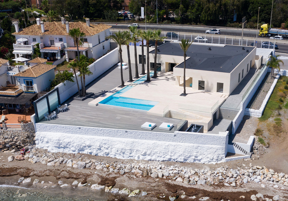 Aerial view of a contemporary villa with private pool and landscaped grounds near the beach in La Cala de Mijas, offering coastal luxury living on the Costa del Sol
