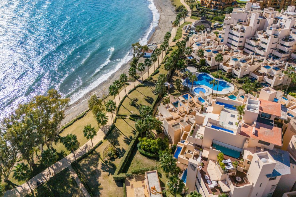 Ático en primera línea de playa con piscina privada y vistas al mar.